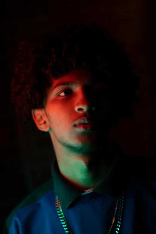a man with a chain around his neck, an album cover, trending on pexels, imaan hammam, ominous neon lighting, looking serious, teenage boy