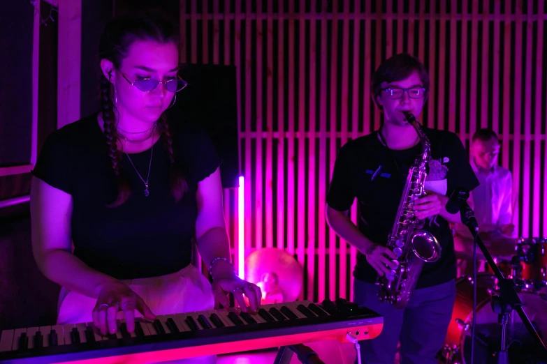 a couple of people that are playing a musical instrument, pink lighting, four legged, sydney hanson, profile image