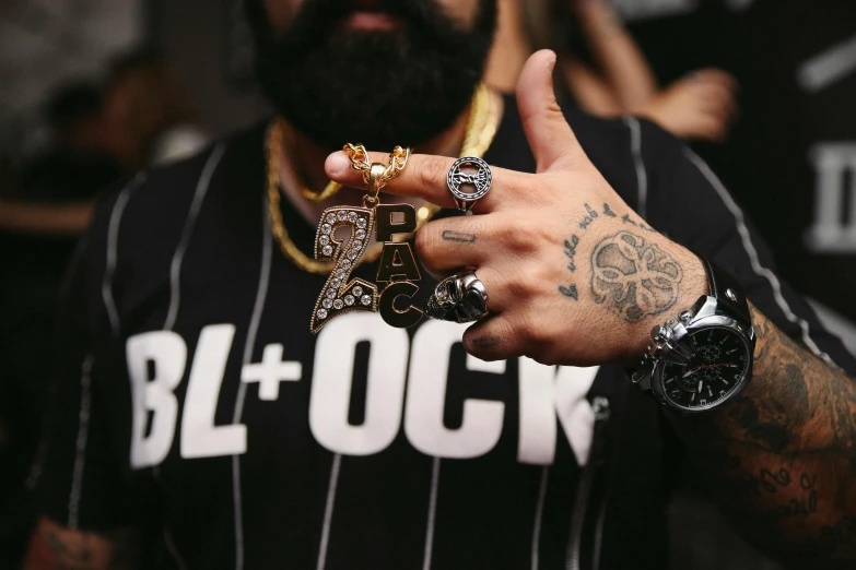 a close up of a person with a ring on his finger, streetwear, glocks, black beard, block party