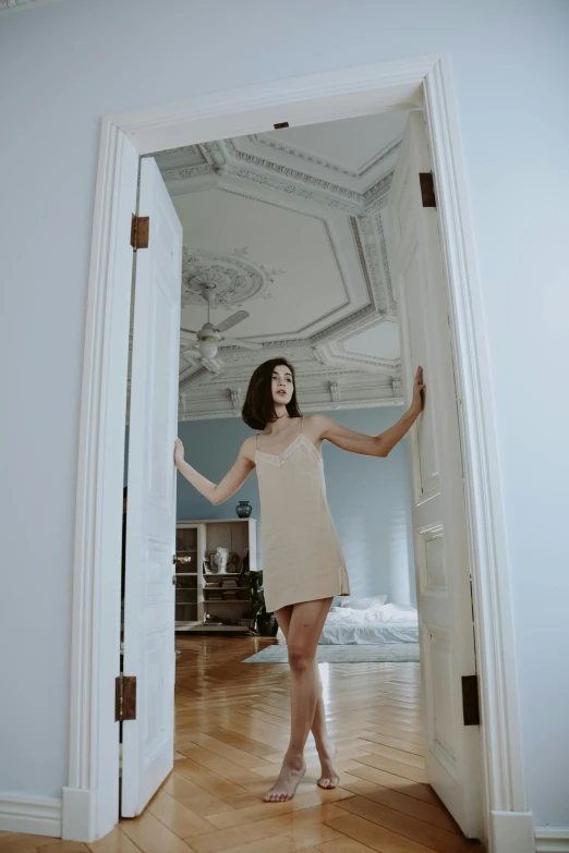 a woman is standing in an open doorway, inspired by Elsa Bleda, rococo, low quality photo, tall ceiling, gemma chan, pose 4 of 1 6