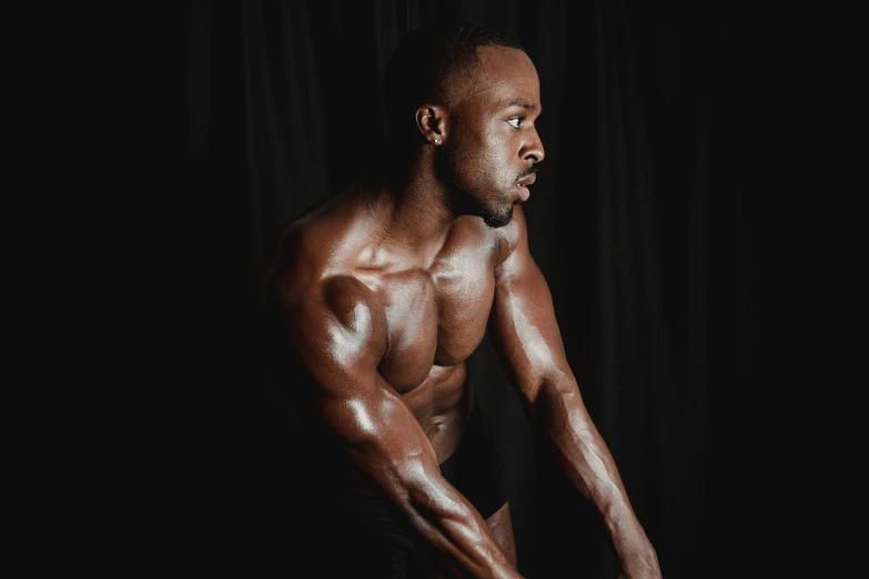 a man standing in front of a black background, by Sam Charles, pexels contest winner, figuration libre, ifbb fitness body, with brown skin, 2 0 0 0's photo, indoor picture