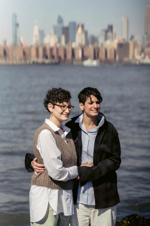 two people standing next to each other near a body of water, queer woman, new york city as backdrop, slide show, rebecca sugar