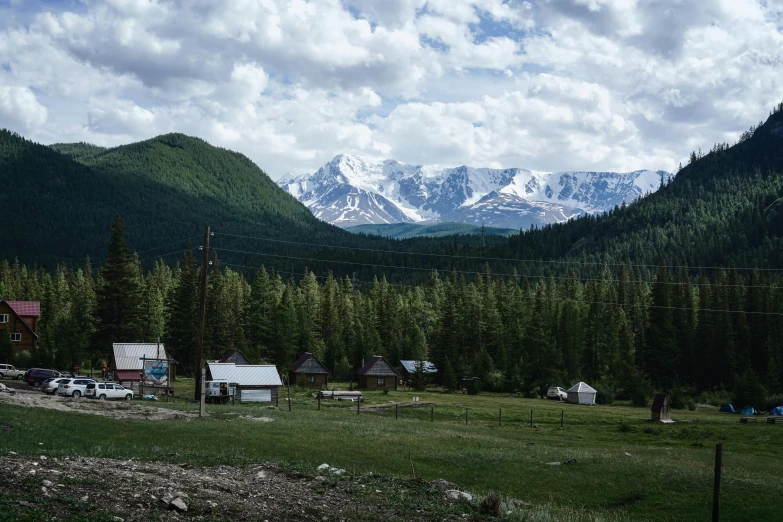 a view of a small town with mountains in the background, inspired by Konstantin Vasilyev, unsplash contest winner, hurufiyya, summer siberian forest taiga, фото девушка курит, kazakh, 2000s photo