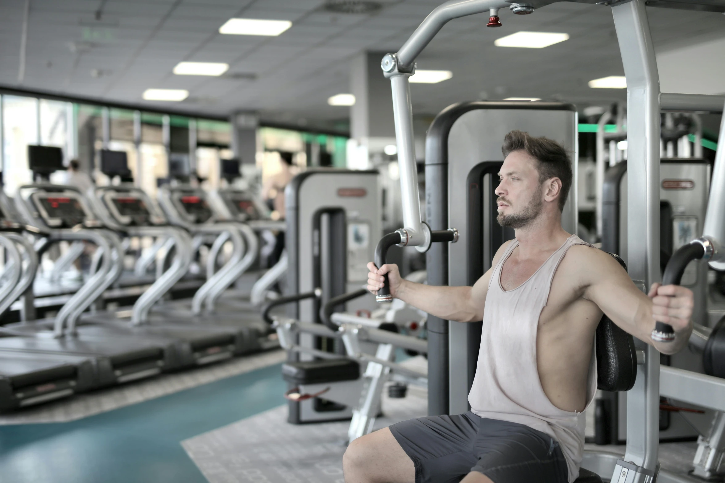 a man sitting on a machine in a gym, by Matija Jama, pexels contest winner, hurufiyya, headshot, high rendering, high quality image