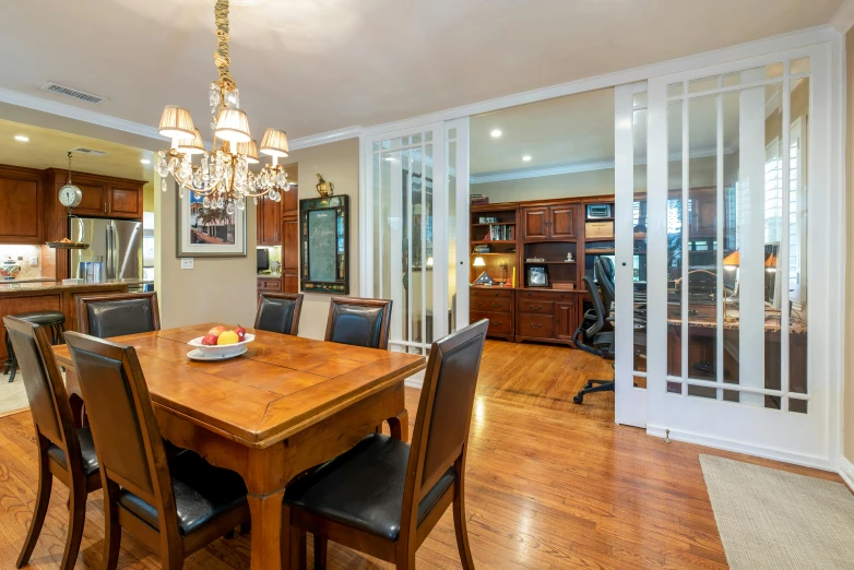 a dining room table with chairs and a chandelier, by Carey Morris, unsplash, nesting glass doors, fan favorite, hardwood floors, slide show