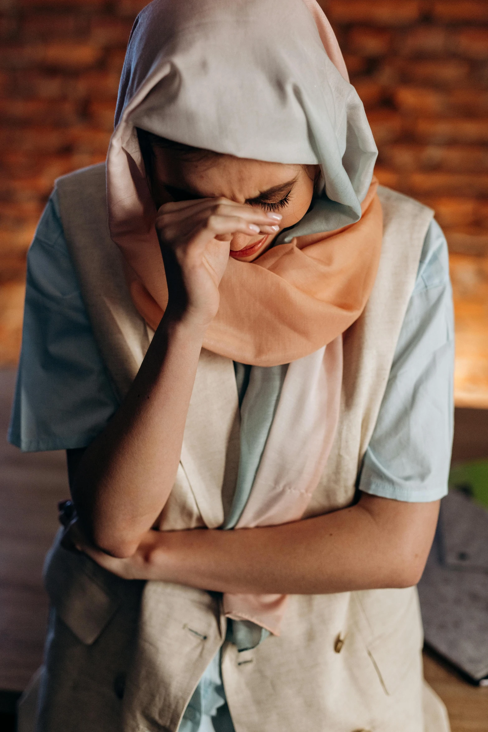 a woman with a scarf covering her face, a picture, shutterstock, hurufiyya, in pain, biblical clothing, at home, cysts