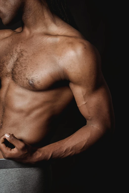 a shirtless man standing with his hands in his pockets, an album cover, by Alexander Mann, trending on pexels, renaissance, large muscles, upper body close - up, african man, working out