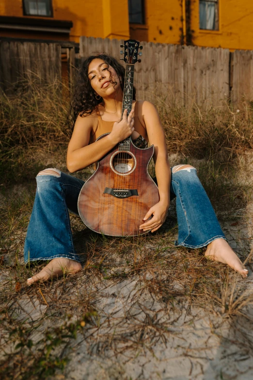 a woman sitting on the ground with a guitar, tessa thompson inspired, acoustic guitar, beaching, profile image