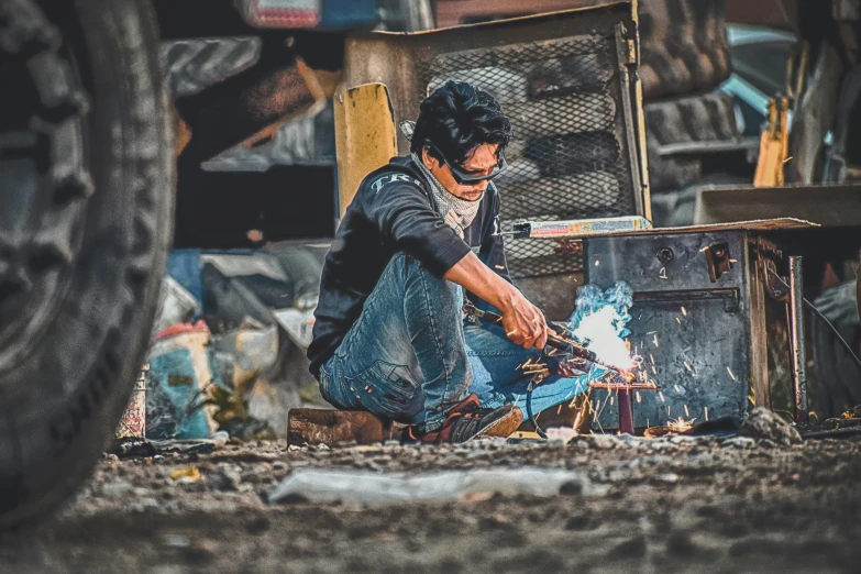 a man working on a piece of metal, pexels contest winner, arbeitsrat für kunst, avatar image, asian man, chaotic riots in 2022, high quality image