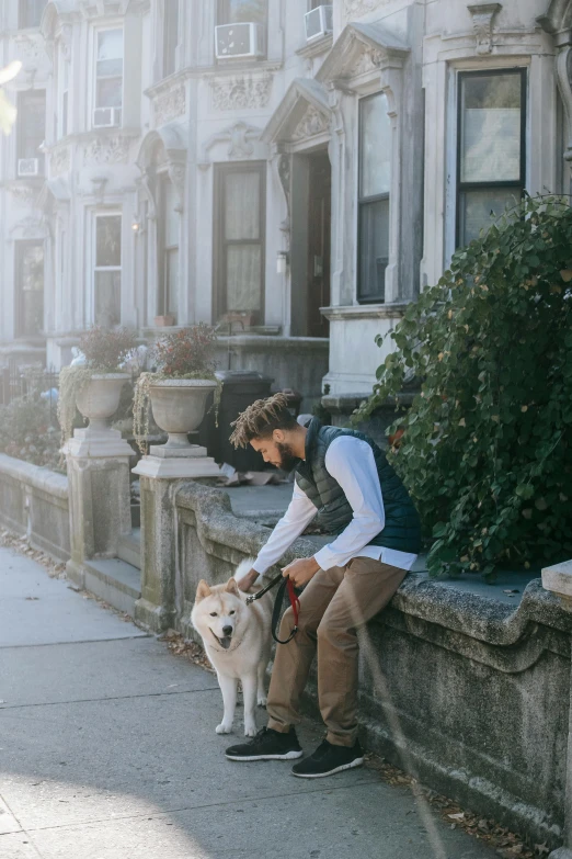 a man sitting on a ledge with his dog, by Washington Allston, trending on unsplash, renaissance, in front of the house, brooklyn, he is a long boi ”