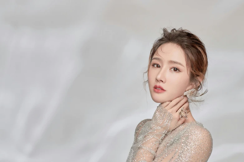 a woman in a silver dress posing for a picture, inspired by Huang Ji, trending on pexels, iu, background image, yanjun chengt, gong li