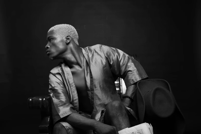 a black and white photo of a man sitting on a chair, an album cover, pexels, lyco art, adebanji alade, white-hair pretty face, portrait of muscular, fashion shoot 8k