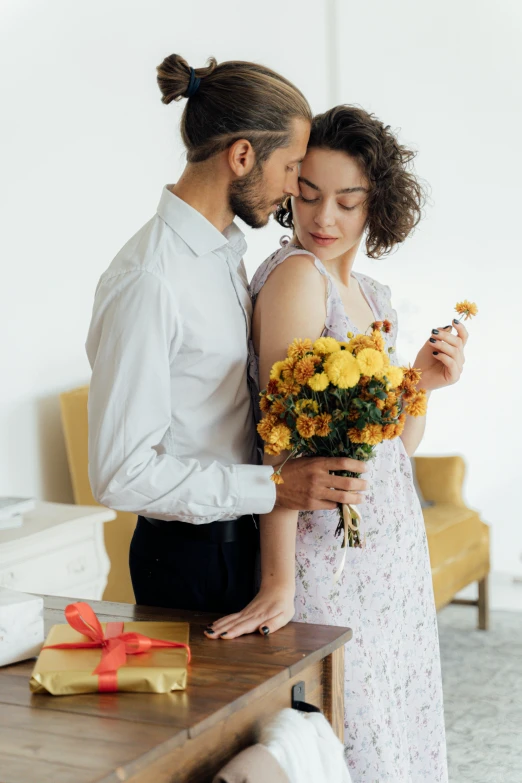 a man standing next to a woman holding a bouquet of flowers, pexels contest winner, lady using yellow dress, on a white table, romantic lead, thoughtful )