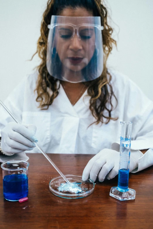 a close up of a person in a lab coat, pexels, process art, experimenting in her science lab, hispanic, invisible woman, tabletop