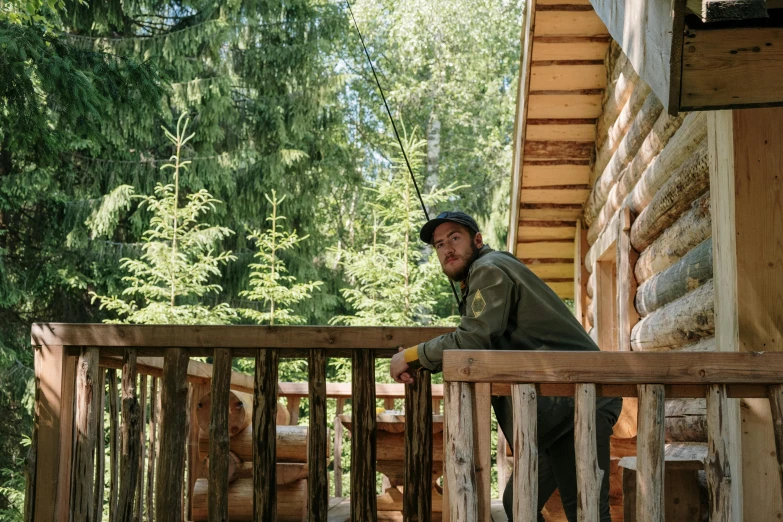 a man standing on the porch of a log cabin, a portrait, unsplash, process art, avatar image, tourist photo, full - body portrait of a ranger, sitting in a tree