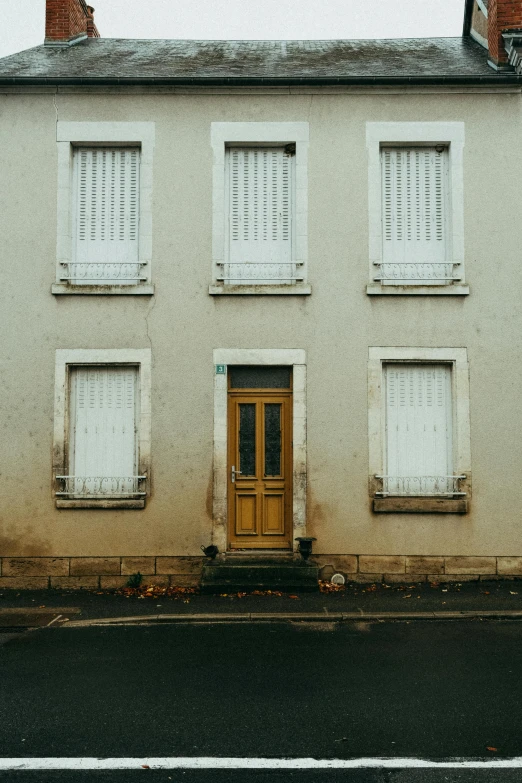 a white house sitting on the side of a road, by Raphaël Collin, pexels contest winner, french door window, yellowed, taupe, frontal picture