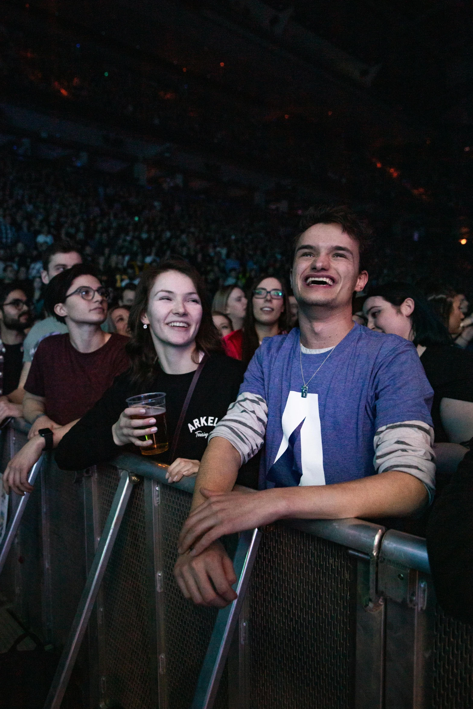 a group of people standing next to each other at a concert, amused, conor walton, crowded stands, looking defiantly at the camera