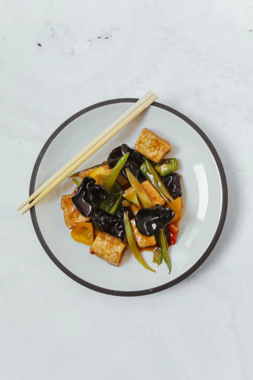 a plate of food with chopsticks on it, square, eggplant, f / 2 0, with black