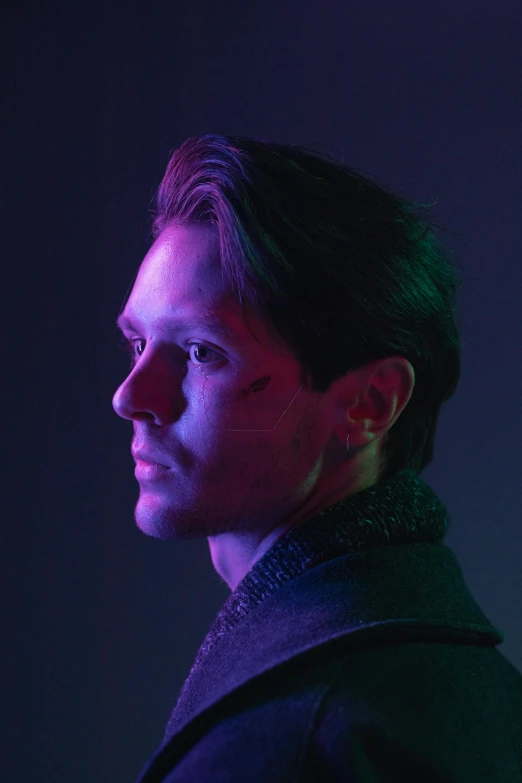 a man standing in front of a purple light, a character portrait, inspired by Julian Allen, pexels, bauhaus, with high cheekbones, facing away from camera, caleb from critical role, tobey maguire