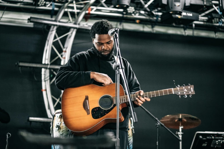a man playing a guitar in front of a microphone, by Niko Henrichon, pexels contest winner, black man, slight overcast, rapping on stage at festival, 15081959 21121991 01012000 4k
