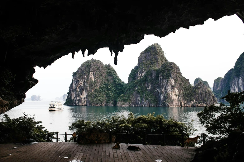 a view of a body of water from inside a cave, inspired by Steve McCurry, unsplash contest winner, visual art, vietnamese temple scene, distant mountains lights photo