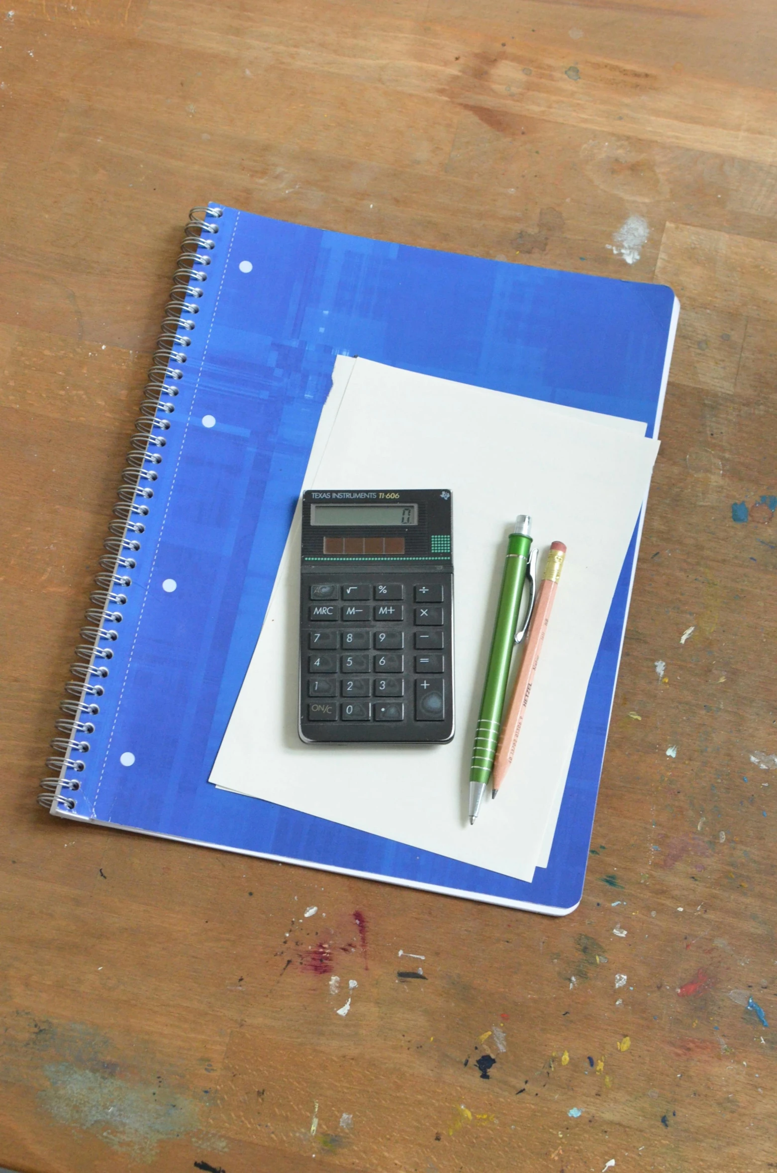 a calculator sitting on top of a wooden table, by Robert Medley, academic art, notebook, blue print, trapper keeper, no - text no - logo