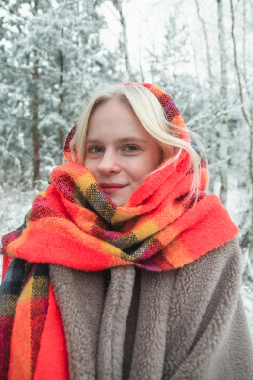 a woman wrapped up in a blanket in the snow, inspired by Louisa Matthíasdóttir, happening, tartan scarf, orange, medium close - up, square