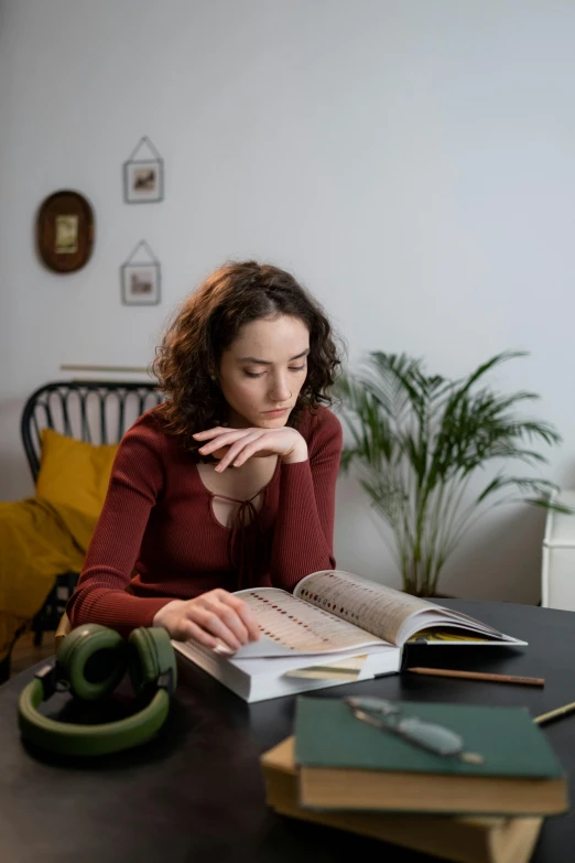 a woman sitting at a table reading a book, studious, gen z, thoughtful ), high-quality photo