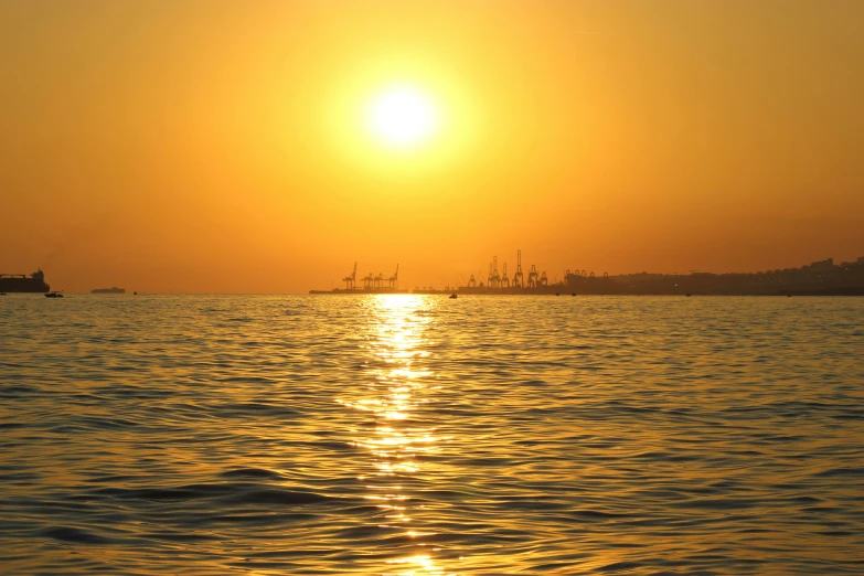 the sun is setting over a large body of water, pexels contest winner, romanticism, yellow, maritime, halogen, port