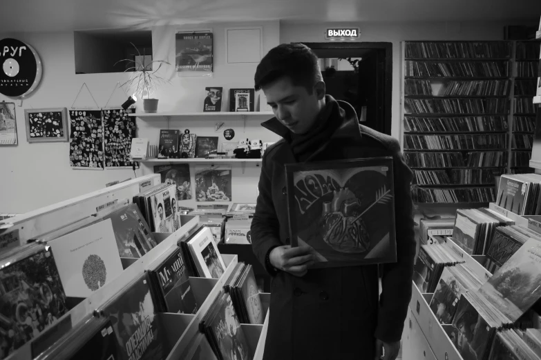 a man holding a record in a record store, an album cover, by Adam Rex, tumblr, monochrome, caspar david, in a desolate, gif