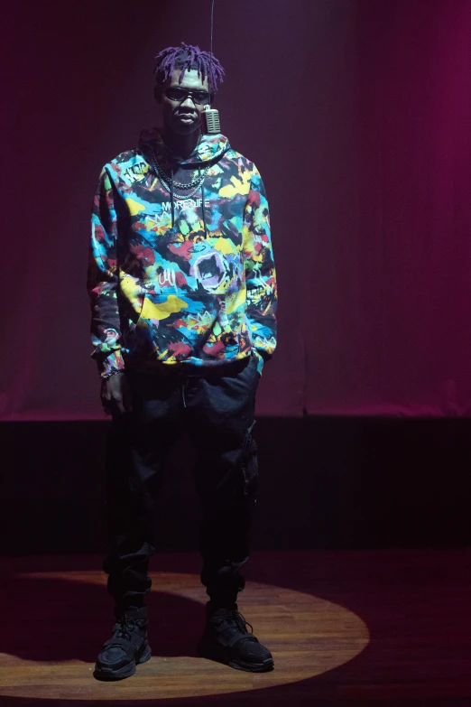 a man standing on top of a wooden floor, inspired by Tomokazu Matsuyama, unsplash, visual art, wearing a dark hood, concert, official store photo, full body visible