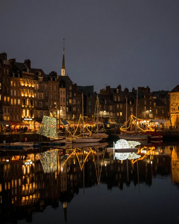 a group of boats sitting on top of a body of water, by Raphaël Collin, pexels contest winner, christmas lights, normandy, square, profile image