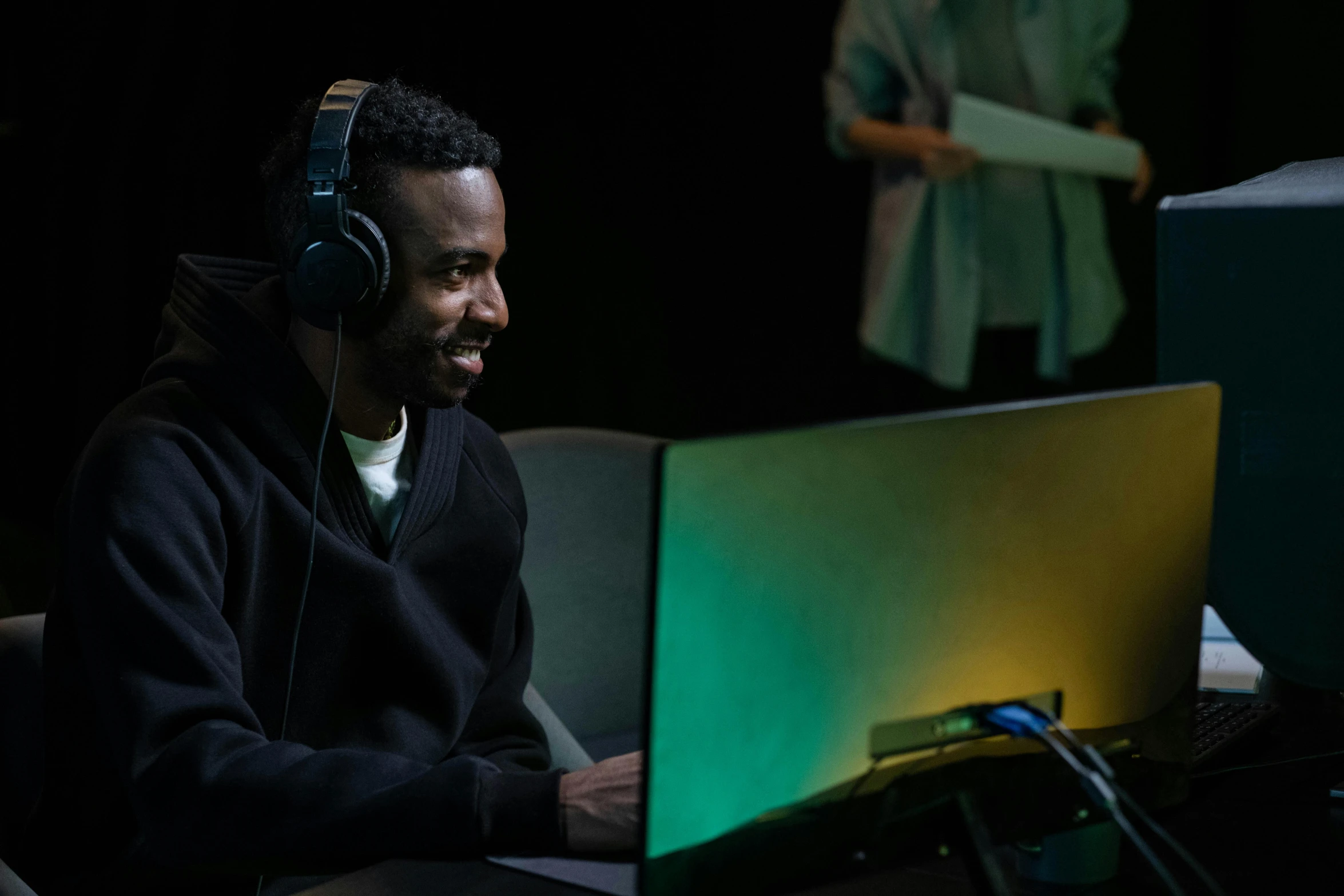 a man sitting in front of a computer wearing headphones, steam workshop, performance, jaylen brown, people enjoying the show