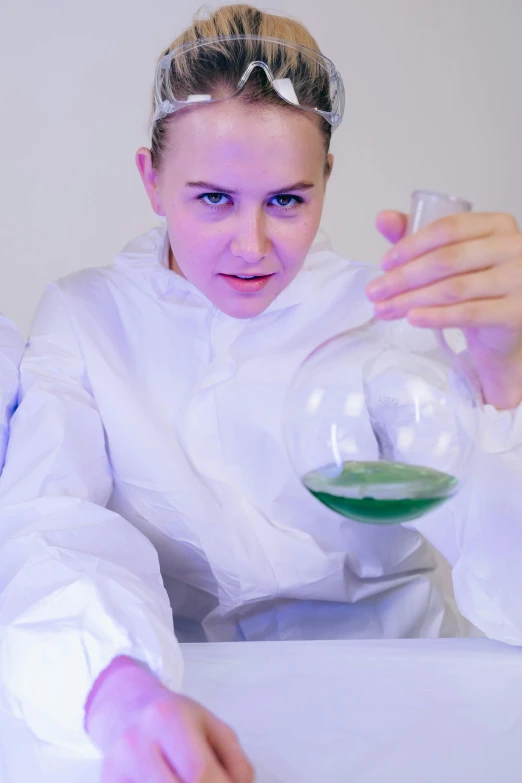 a woman in a lab coat holding a flask filled with green liquid, bubbling ooze covered serious, dasha taran, biroremediation, barreleye