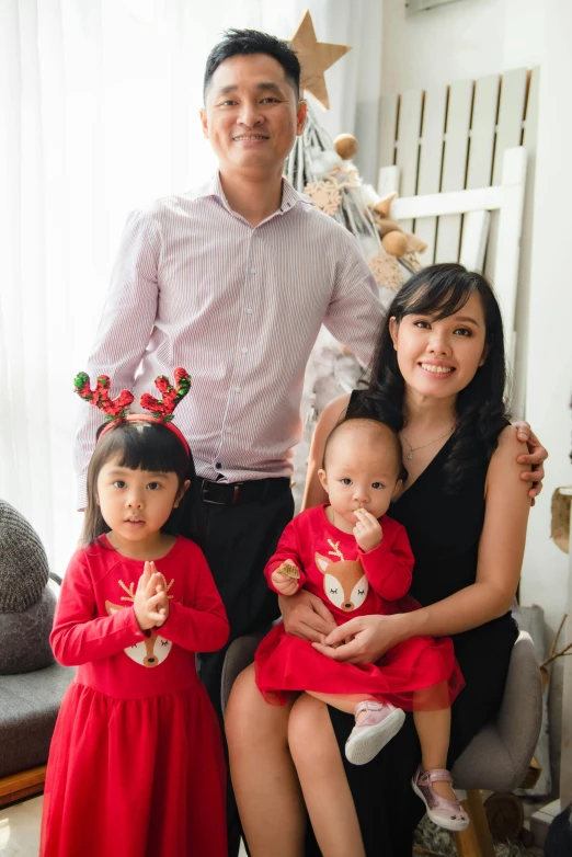 a family posing for a picture in a living room, inspired by Ni Duan, instagram, wearing festive clothing, profile image, studio photoshot, corporate photo