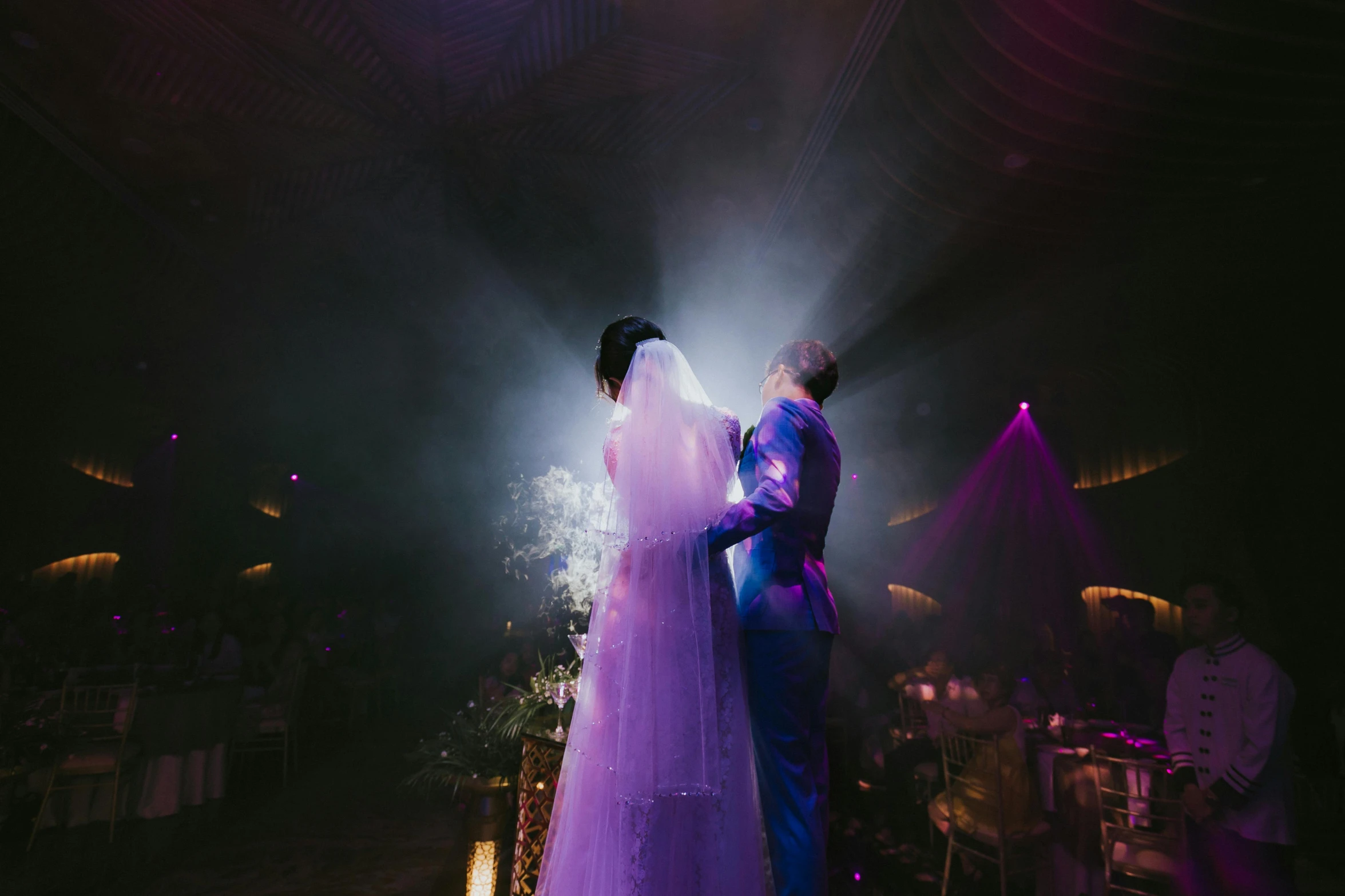 a couple standing next to each other on a dance floor, pexels contest winner, light and space, purple robe and veil, jordan grimmer and natasha tan, stage lighting, haze over the shoulder shot