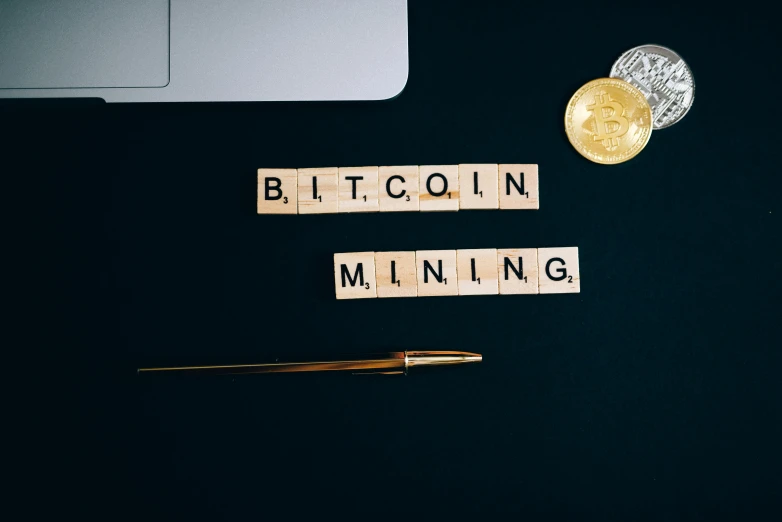 the word bitcoin mining spelled in scrabbles next to a laptop, by Julia Pishtar, trending on unsplash, happening, portrait of small, miners, business logo, f