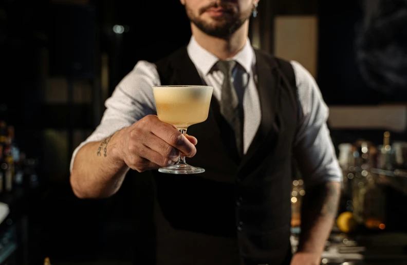 a man in a vest and tie holding a drink, inspired by Carlo Martini, pexels contest winner, renaissance, aussie baristas, vintage glow, recipe, thumbnail