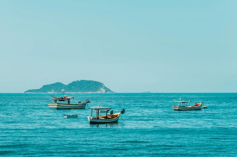 a group of boats floating on top of a body of water, by Elsa Bleda, pexels contest winner, sumatraism, clear blue sky vintage style, rio de janeiro, croatian coastline, photographic print