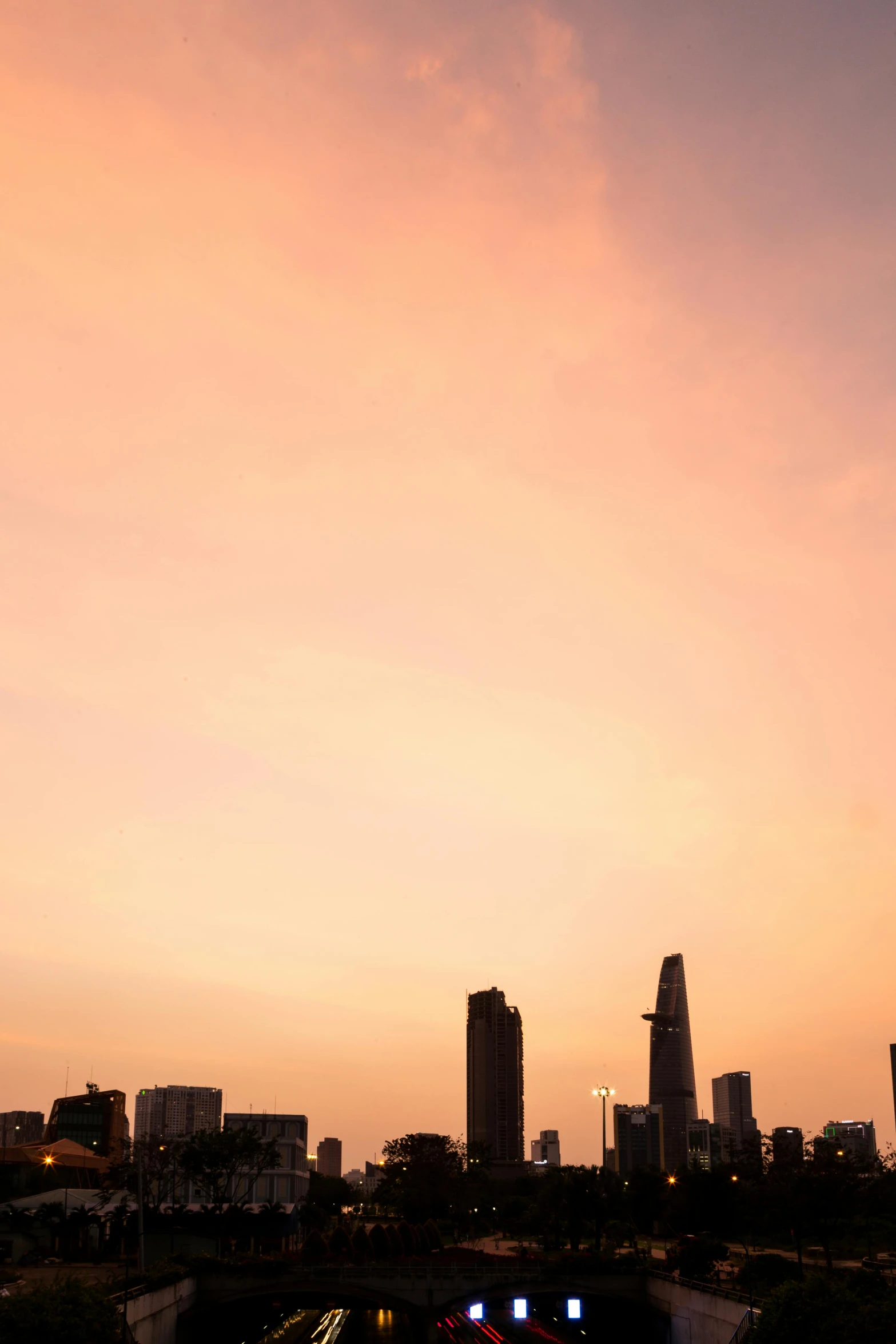 a train traveling through a city next to tall buildings, a picture, by Sven Erixson, minimalism, sunset panorama, vietnam, pastel', high res photograph