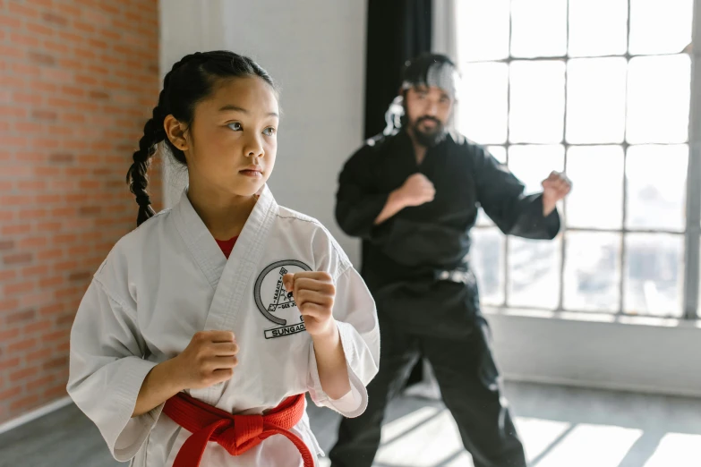 a woman standing next to a man in a room, inspired by Liao Chi-chun, fist training, profile image, kids, medium level shot