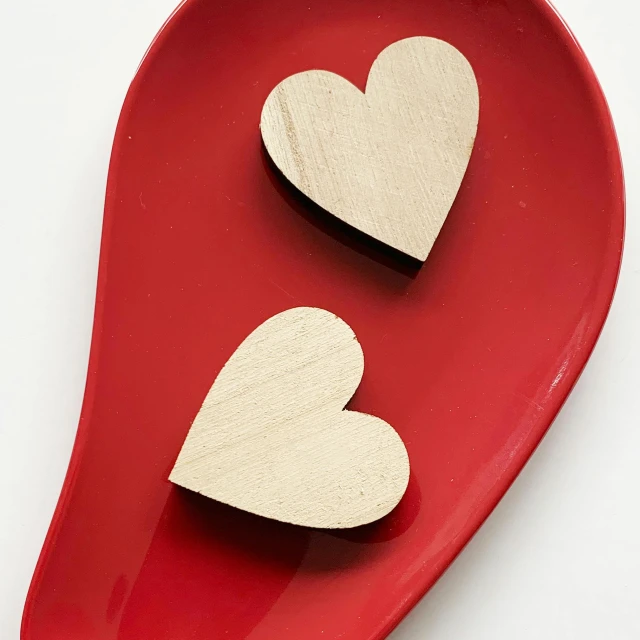 two wooden hearts on a red plate, inspired by Valentine Hugo, small canoes, plain, blonde, product design shot