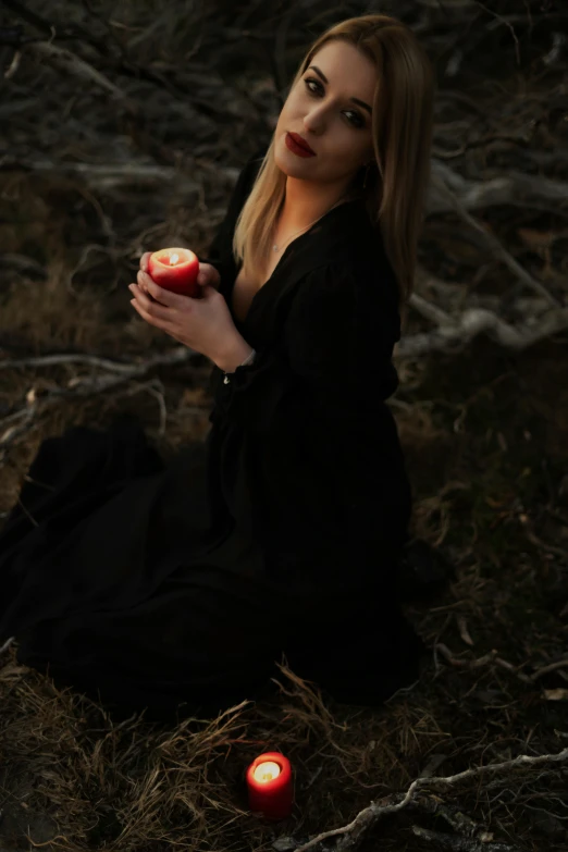 a woman sitting on the ground holding an apple, inspired by Brooke Shaden, pexels contest winner, renaissance, black robes, 15081959 21121991 01012000 4k, holding a drink, /!\ the sorceress