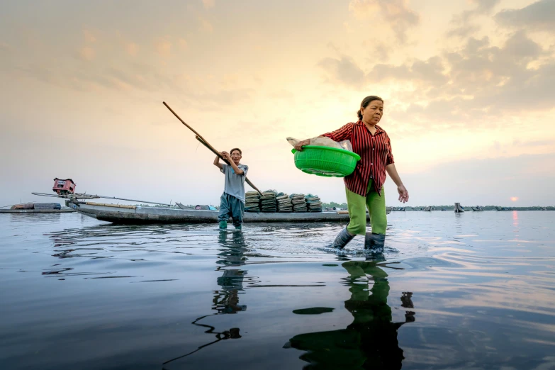 a couple of people standing on top of a body of water, a portrait, flooded fishing village, national geographic quality, sun set, nets and boats