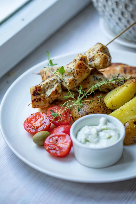 a close up of a plate of food on a table, by Mathias Kollros, unsplash, greek style, chicken, square, potato