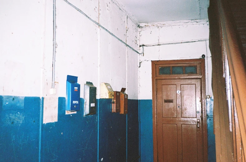 a blue and white bathroom with a wooden door, an album cover, by Attila Meszlenyi, 1999 photograph, soviet yard, in school hallway, 1990s photograph