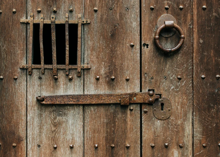 a close up of a wooden door with a barred window, an album cover, pexels, renaissance, made of wrought iron, medieval weapon, 14th century, wabi - sabi