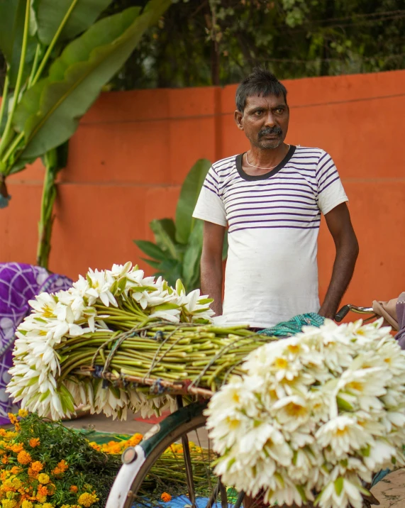 a man standing next to a bicycle filled with flowers, sri lanka, profile image, multiple stories, thumbnail