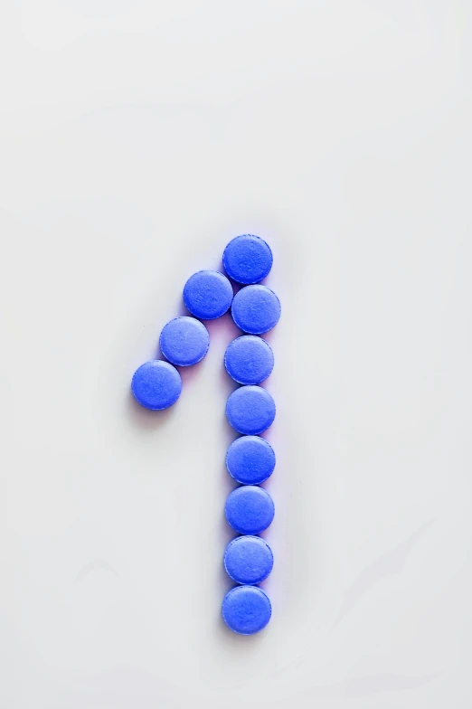 a number made out of blue pills on a white surface, by Adam Marczyński, trending on pexels, antipodeans, purple tubes, lollipop, back facing, symbol