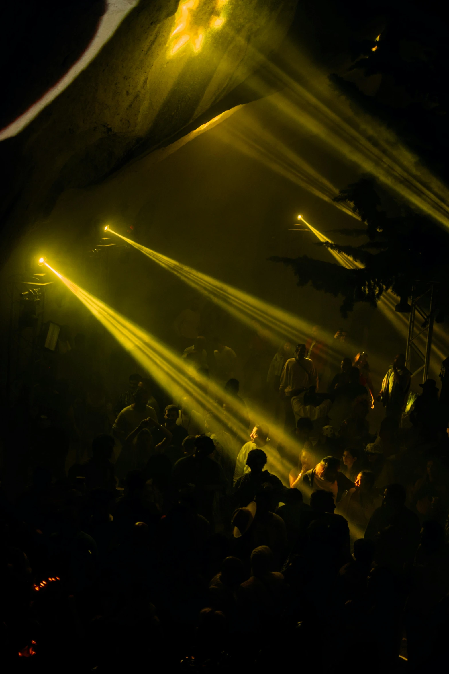 a group of people that are standing in the dark, pexels, light and space, dancefloor kismet, yellow lighting from right, light breaks through the roofs, taken in the late 2010s